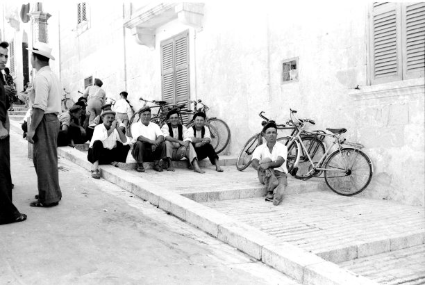 A group of friends sitting atop the steps leading up to the Citadel in Victoria, captured by Emmanuel Borg from Kalkara, 1960s.
