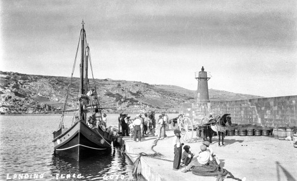A dghajsa tal-latini unloading its wares in Gozo, 1920s.