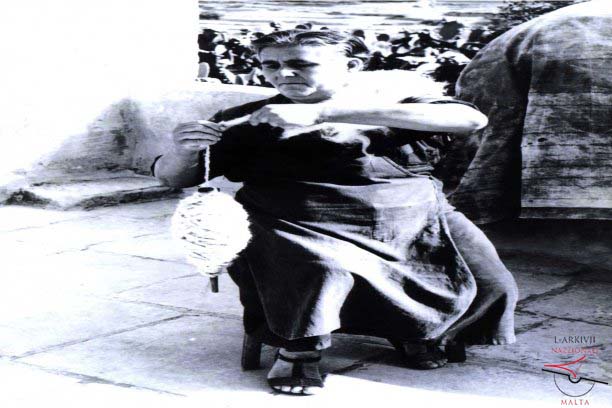 Woman making thread from wool