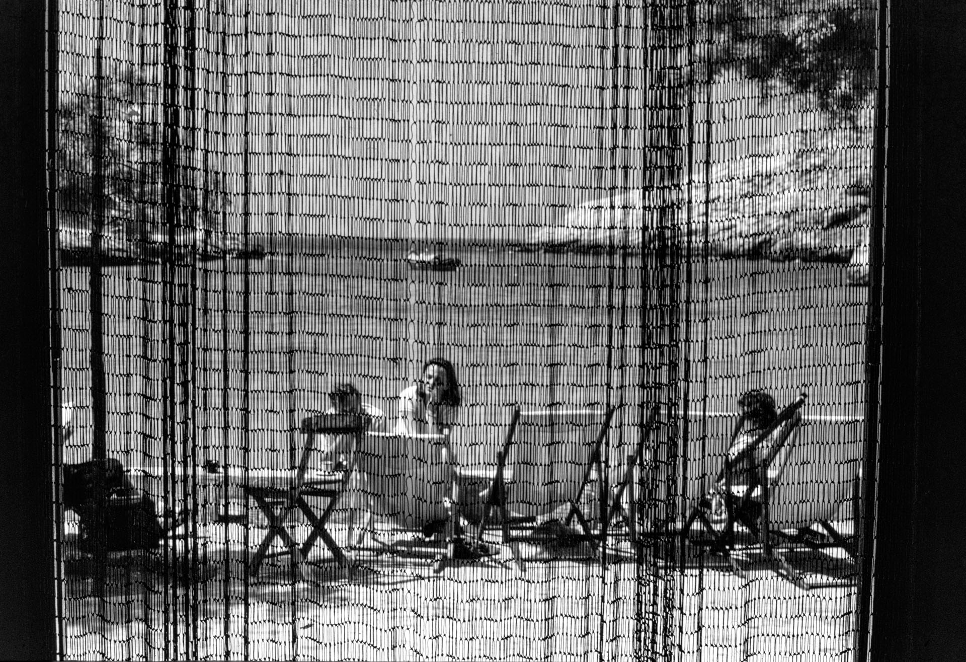 A view of Xlendi Bay through the texture of an abode's door curtain, as captured by Guido Stilon in 1958. Courtesy of Grace Cilia Vincenti & National Archives of Malta.