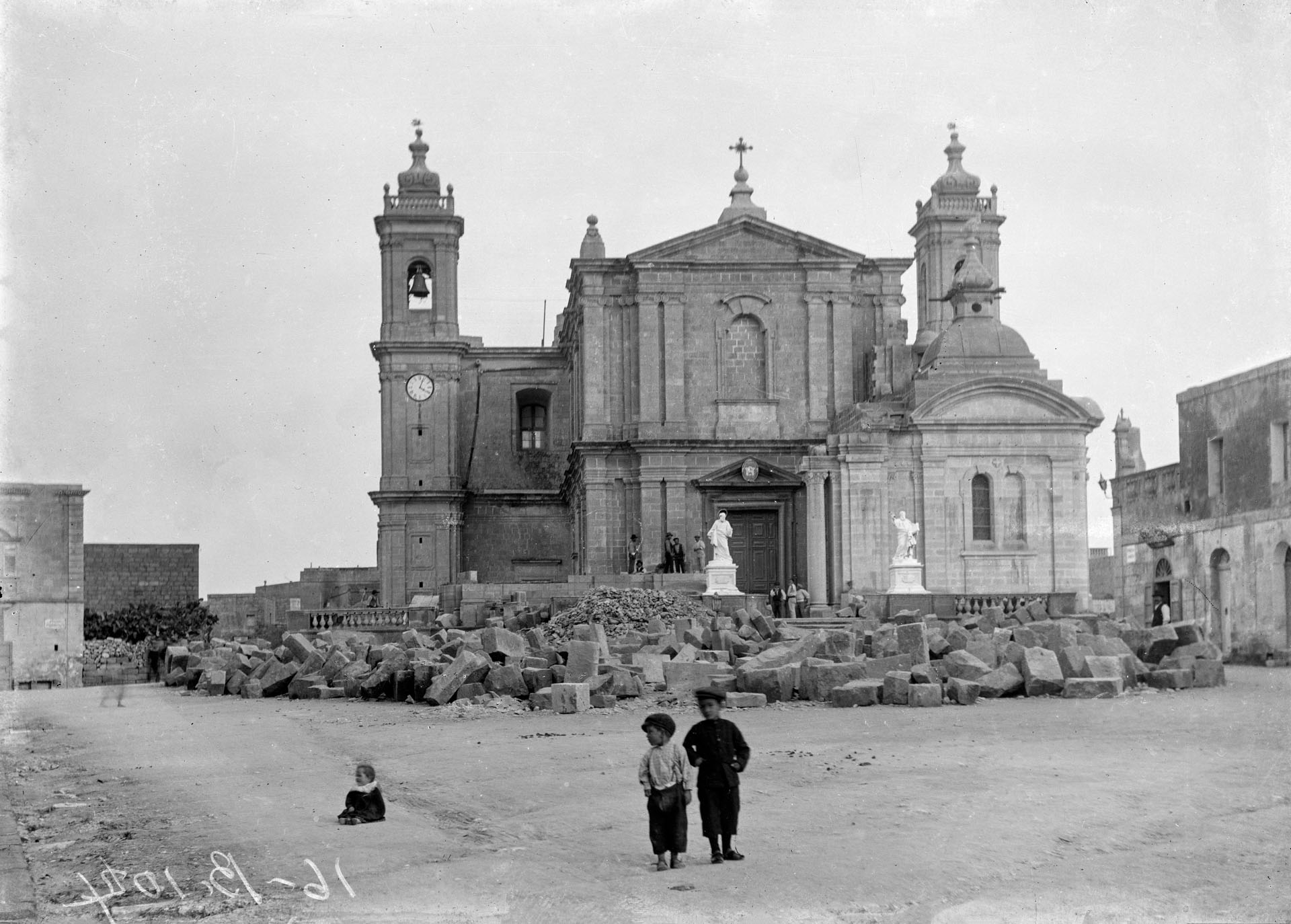 The main square of Nadur showing the enlargement of the main parish church, which commenced in 1913. Attributed to Emanuele Sciortino.