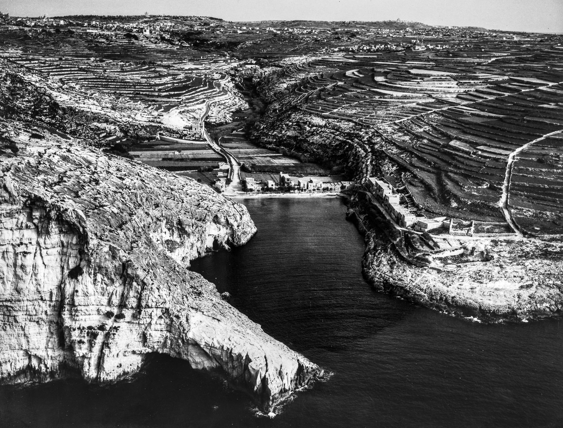 An aerial view of a very different Xlendi Bay than today, captured in a survey from 1958; photographer unknown.