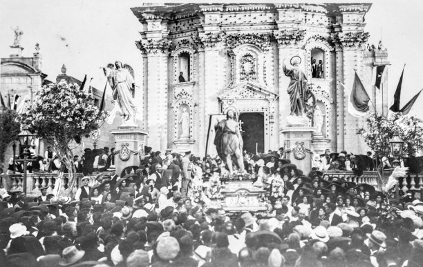 The festivities of St John the Baptist being celebrated in Xewkija in 1928, also showing the old oratory building; photographer unknown.
