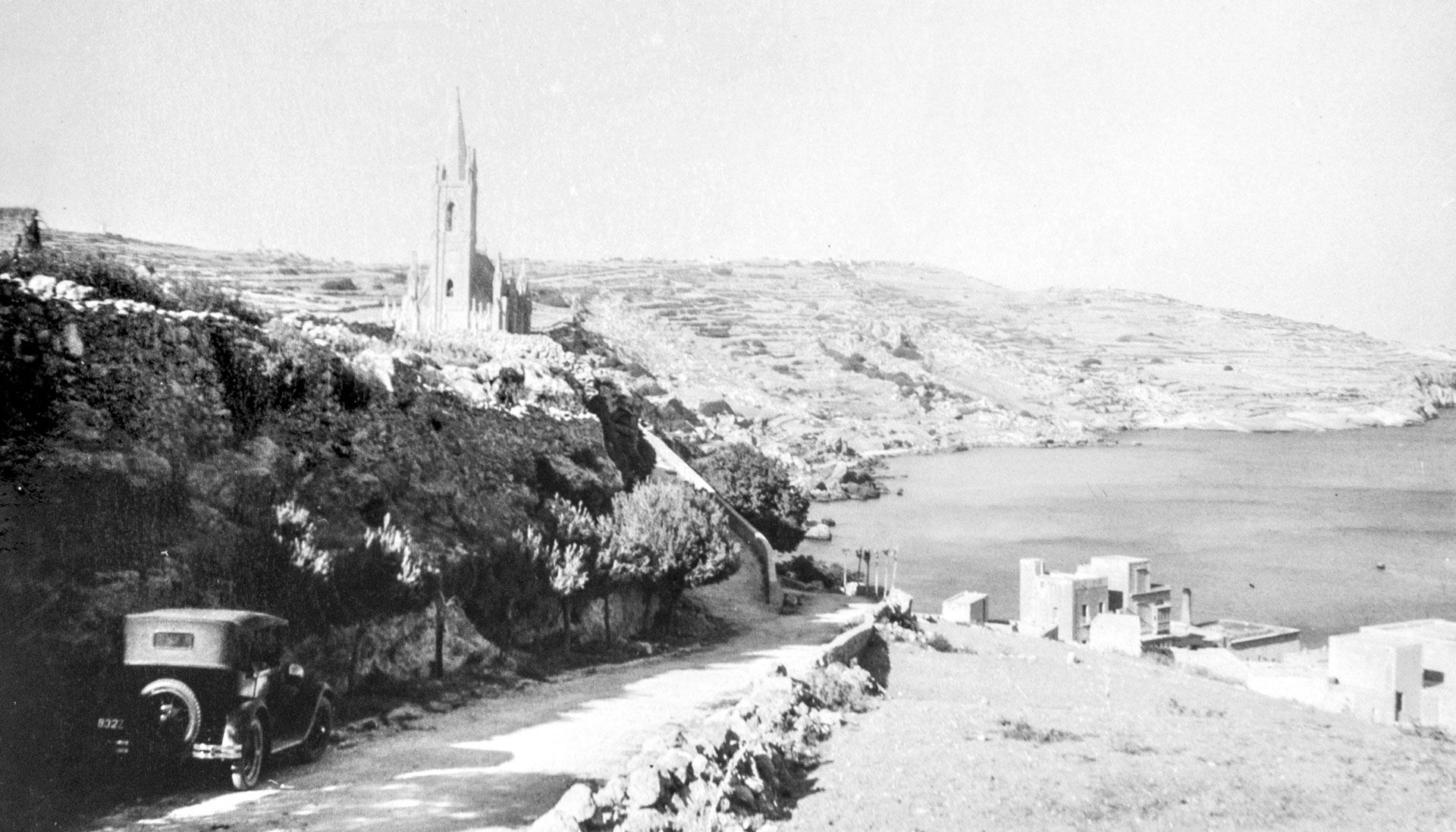 A view of Mgarr Harbour with our Lady of Lourdes chapel in the background, captured by Geo Furst, 1930.