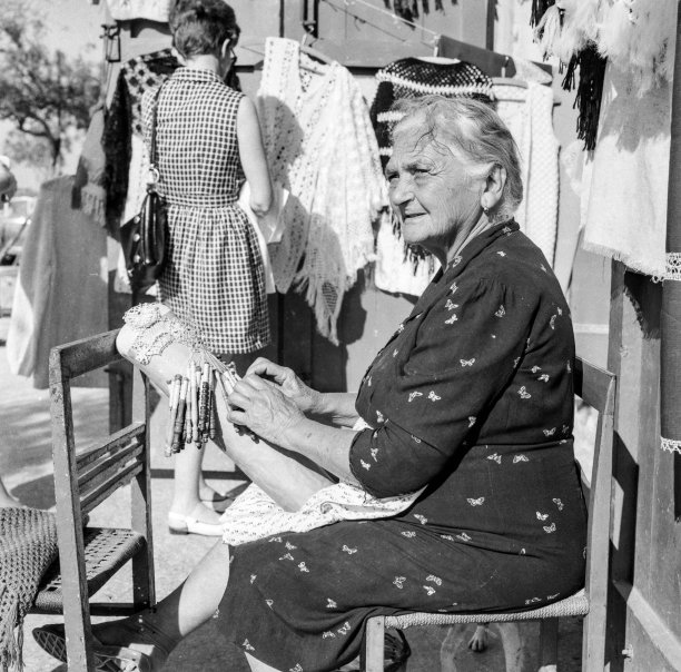 A lace worker showcasing her skill near Banca Giuratale in the 1970s, captured by Gino Theuma.