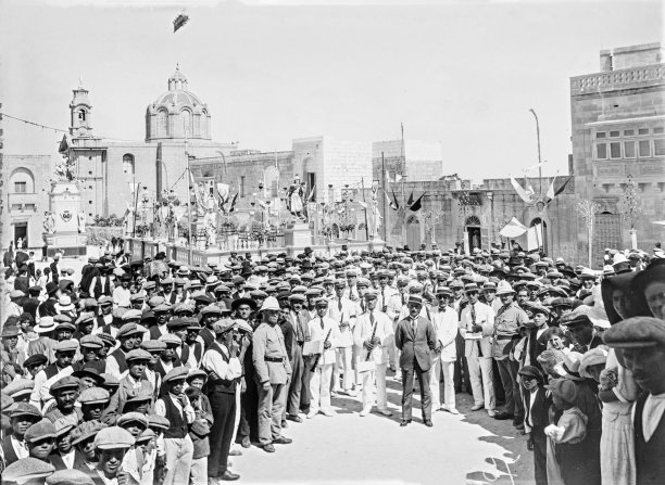 A procession in Nadur, with a throng of ghonnella wearing women behind the procession, 1920s