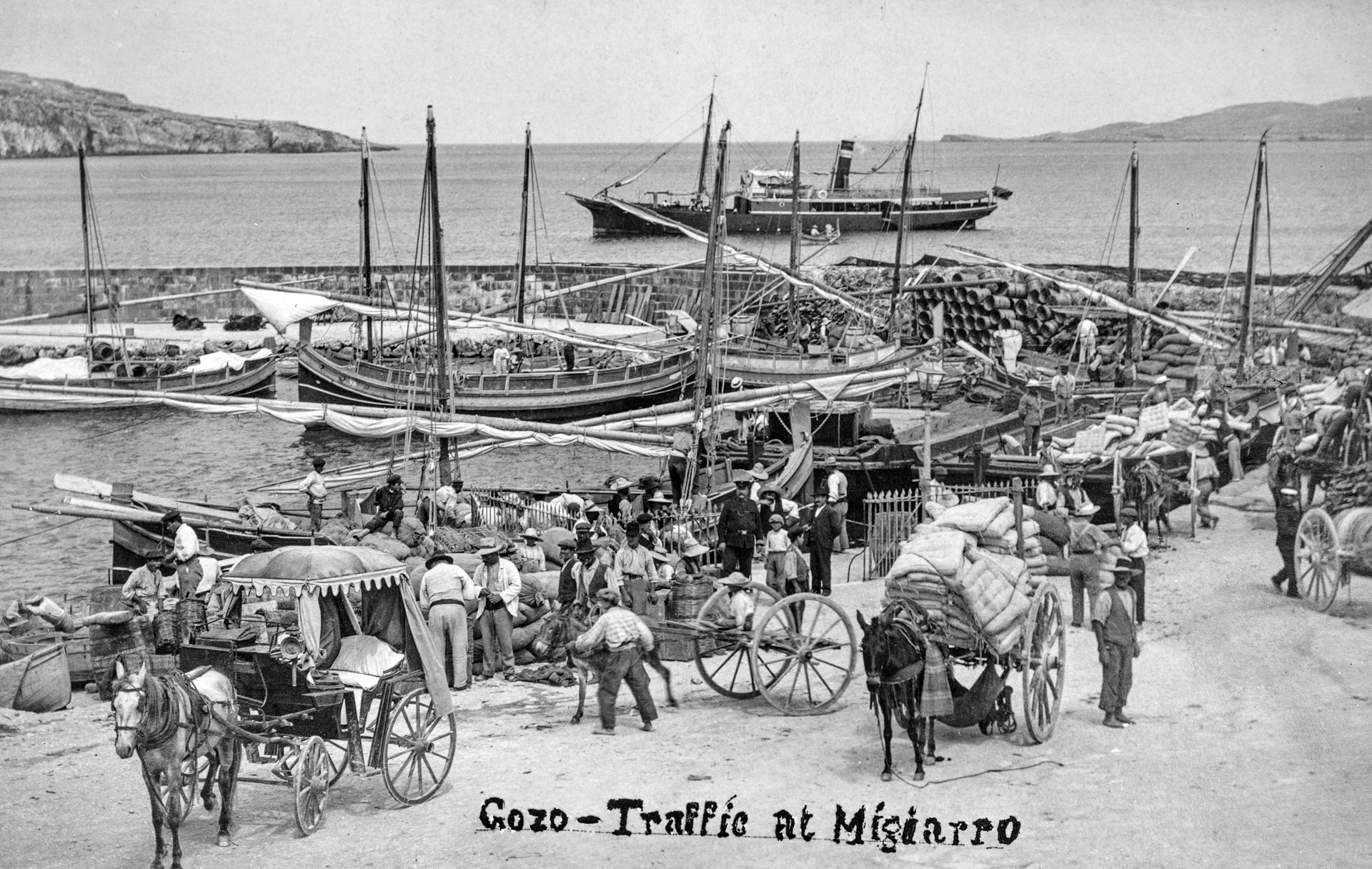 Wares being unloaded at Mgarr harbour, captured by Salvatore Lorenzo Cassar, circa 1910.