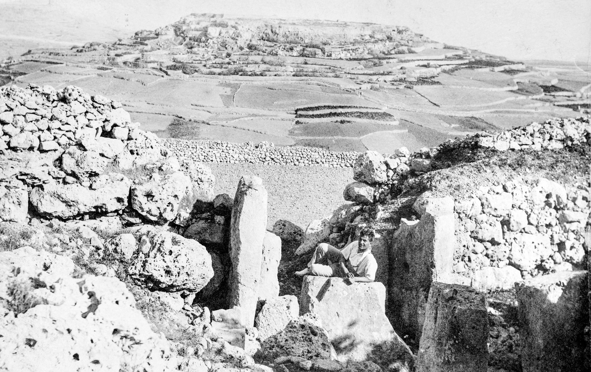 A man lies atop a megalith within Ggantija temples in Xaghra; photographer unknown.